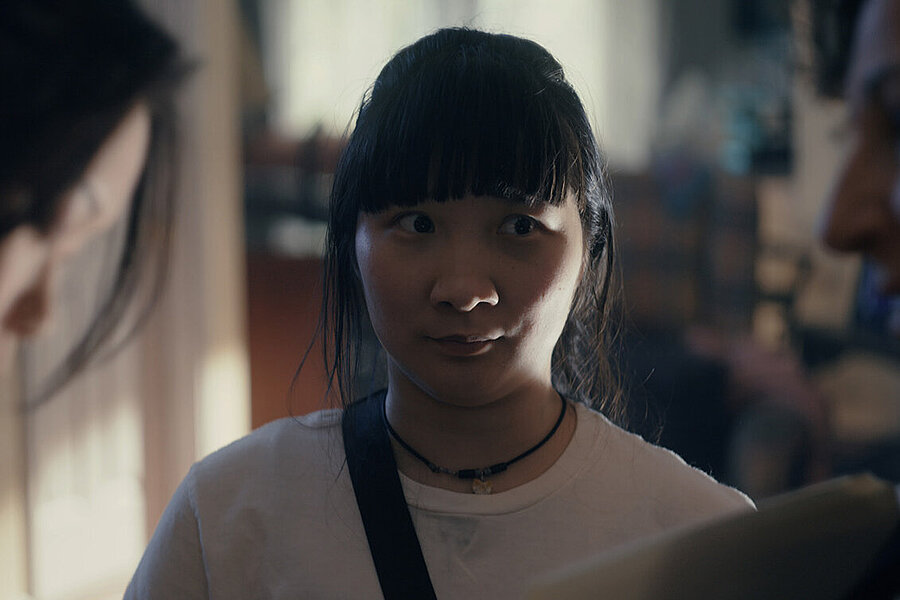 A young woman between two other women.