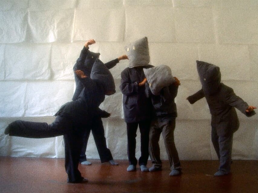Film Still: Gernot Wieland, Bird in Italien is Uccello. Menschen mit Masken auf dem Kopf / People with masks on their heads