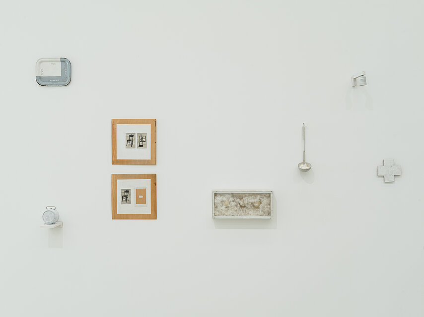Various objects and small pictures on a white wall