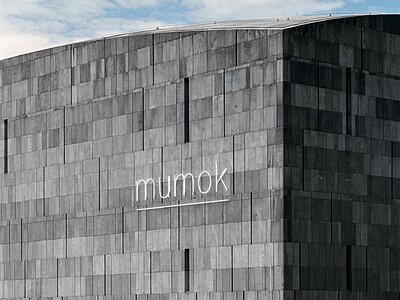 [Translate to English:] Außenansicht des mumok: Graue Außenfassade mit mumok Schriftzug