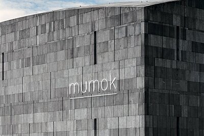 Außenansicht des mumok: Graue Außenfassade mit mumok Schriftzug