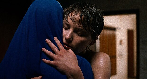 
            
                Filmstill, eine Frau umarmt eine Frau mit Hijab
            
        