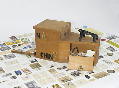 Wooden shoeshine box with cast-iron footrest and metal letters; complex (500) of ephemera, photographs, sheets of text, sketches, objects