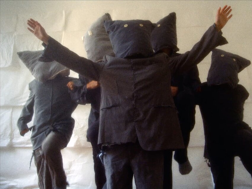 Film Still: Gernot Wieland, Bird in Italien is Uccello. Menschen mit Masken auf dem Kopf / People with masks on their heads