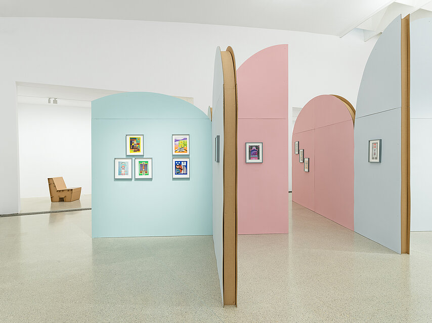 Colourful, semi-circular walls in the exhibition space, with colourful collages in A4 format on them