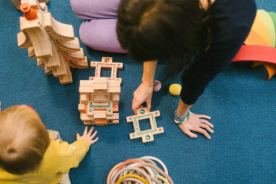 Erwachsene und Kinder in der mumok Freispielstation mit verschiedenen Spielsachen und Materialien