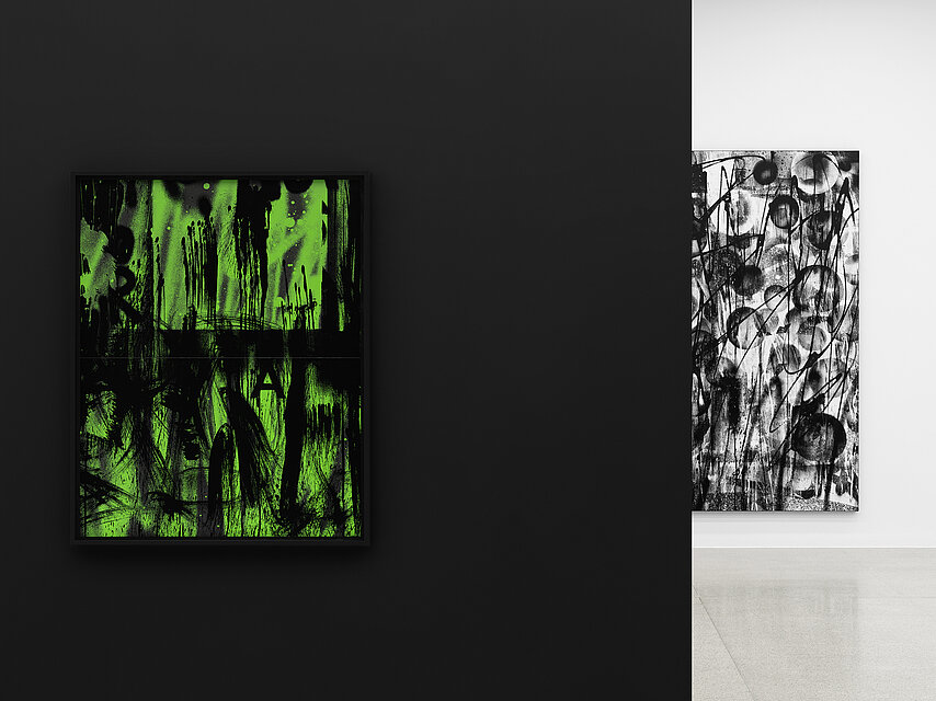  View of an exhibition by Adam Pendleton, on the left on a black wall a painting with abstract neon green and black patterns, on the right in the background on a white wall a black and white abstract painting