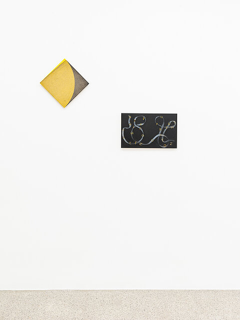 Small abstract paintings in yellow and black on a white wall