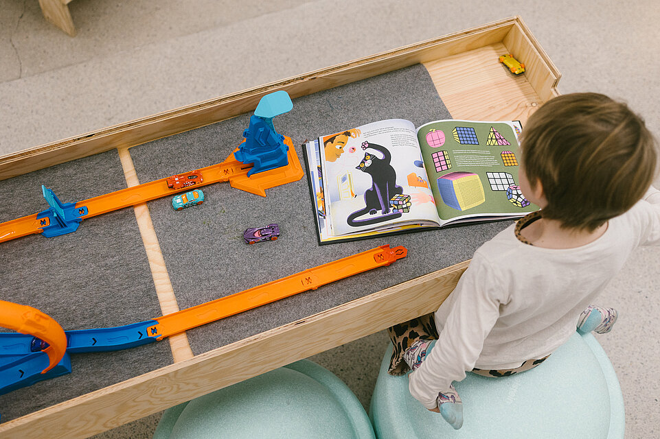 Erwachsene und Kinder in der mumok Freispielstation mit verschiedenen Spielsachen und Materialien