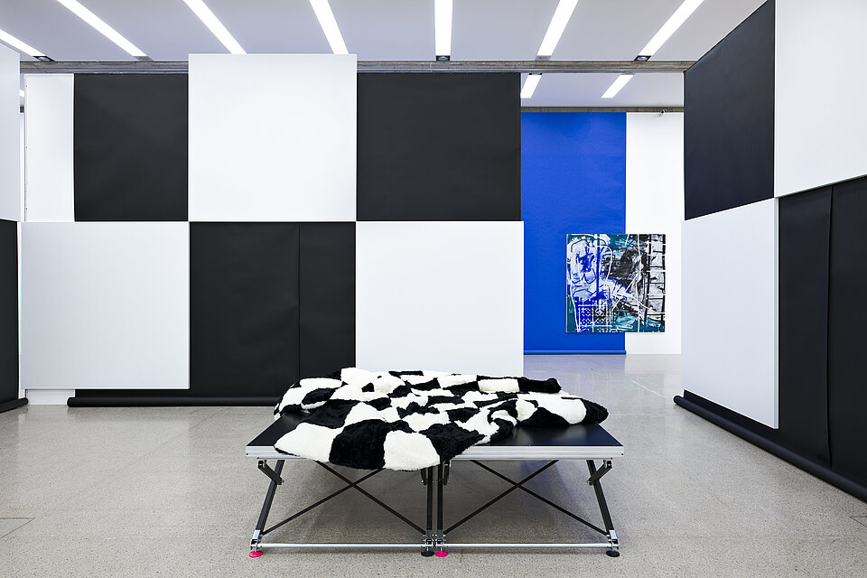In front of two walls in a chequerboard pattern are two platforms with a black and white ceiling on top.
