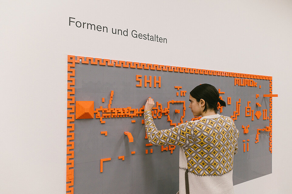 Erwachsene und Kinder in der mumok Freispielstation mit verschiedenen Spielsachen und Materialien