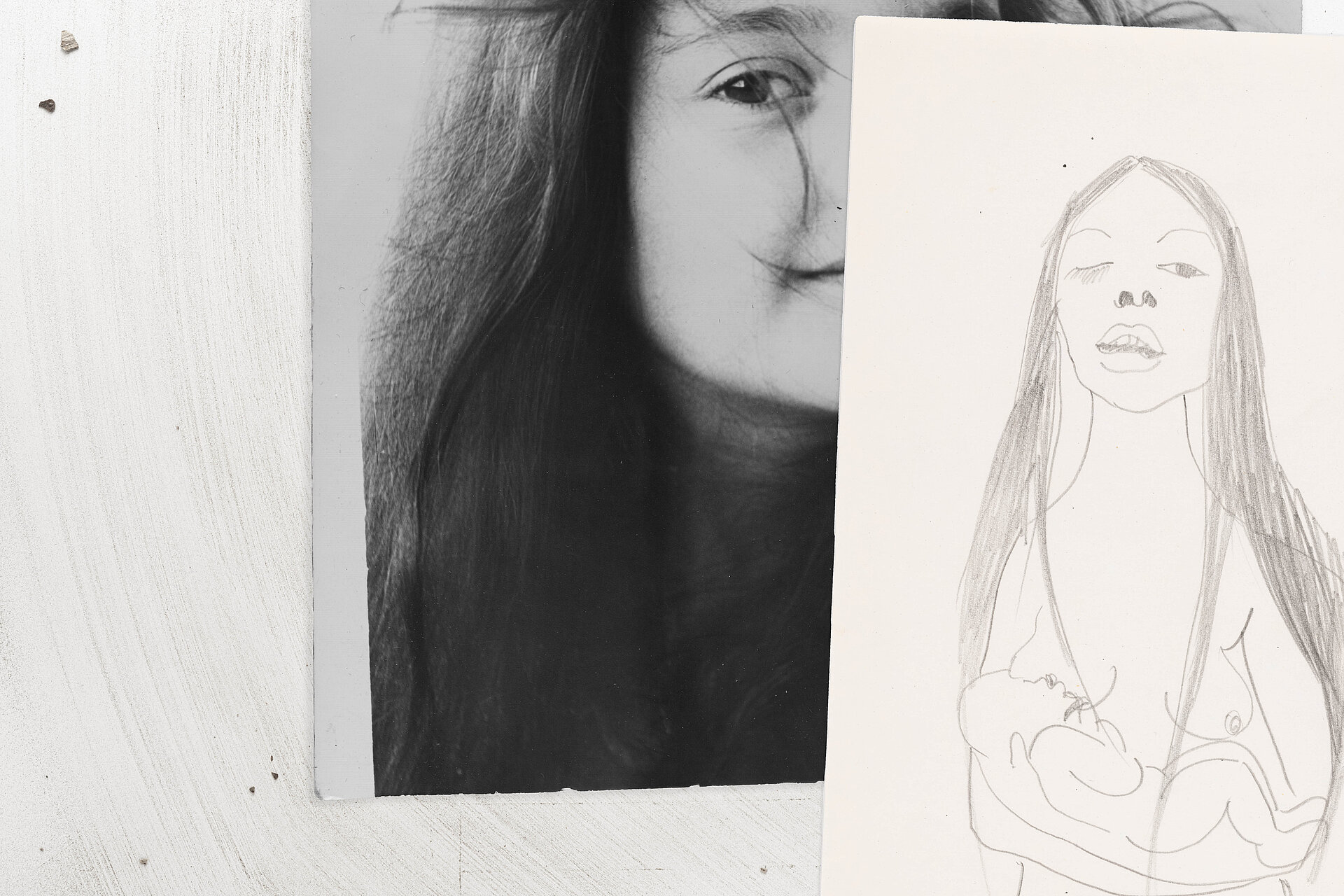 Teilansicht eines schwarz-weißen Porträts auf Papier, links ein Auge und Haarpartien, rechts überlagert von einer einfachen Bleistiftzeichnung einer stehenden menschlichen Figur. / Partial view of a black-and-white portrait on paper, showing an eye and hair on the left, overlaid on the right by a simple pencil drawing of a standing human figure.