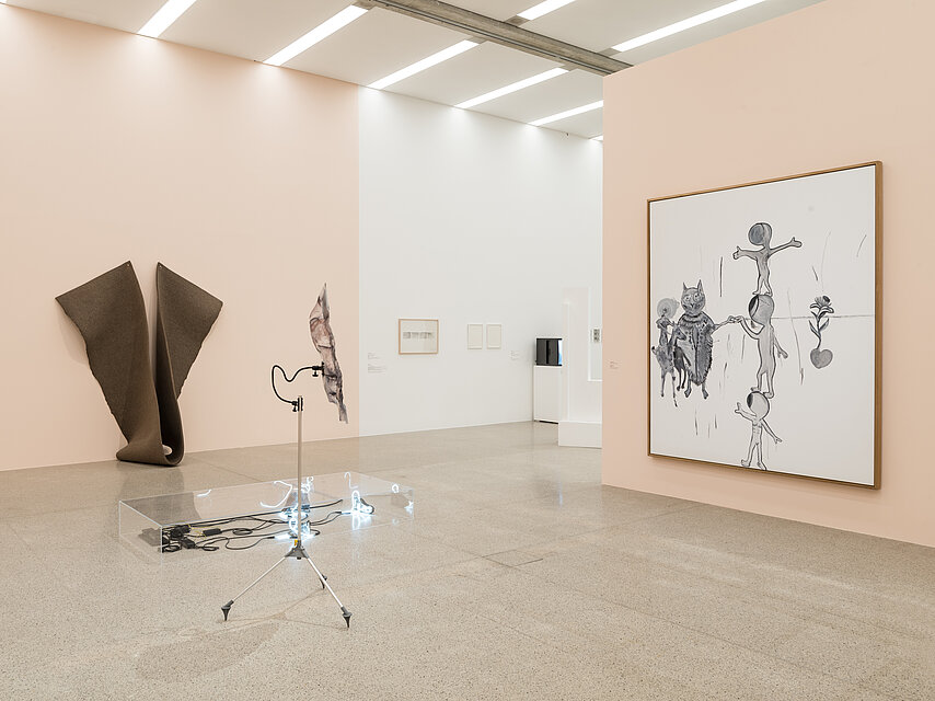 Exhibition room with light pink walls, a large white painting on the right wall, a dark abstract object at the back left