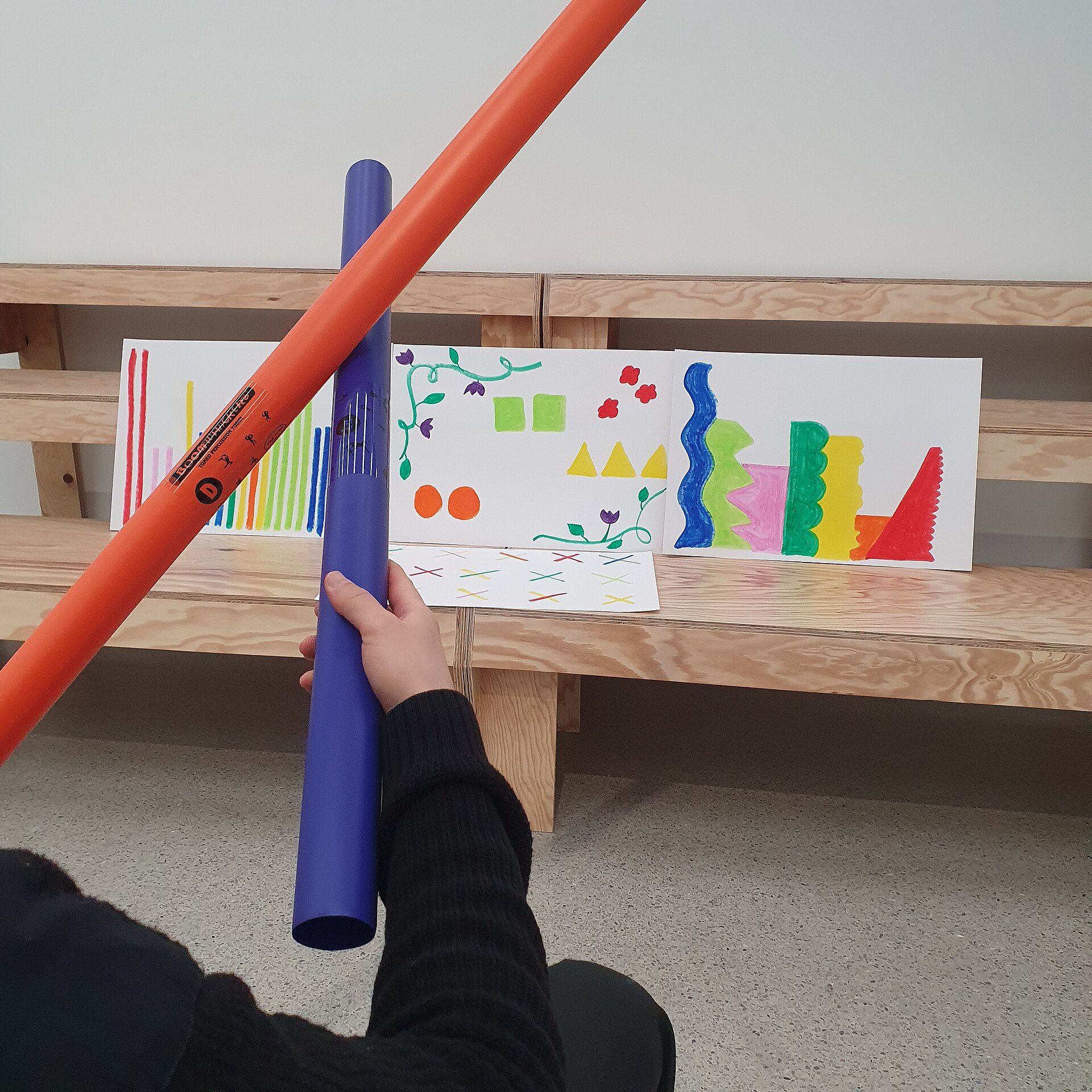 Hände mit Boomwhackers und bunten Bildern
