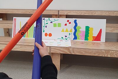 Hände mit Boomwhackers und bunten Bildern