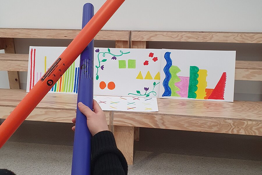 Hände mit Boomwhackers und bunten Bildern