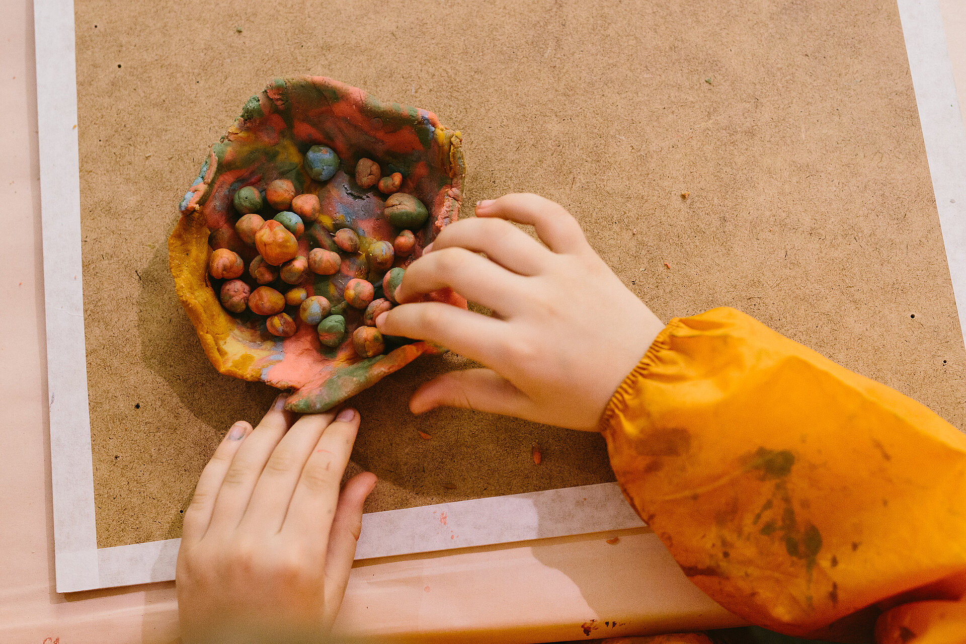 Kinderhände basteln mit Knetmasse oder Ton kleine Kugeln