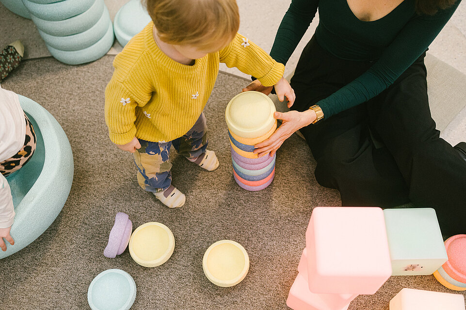Erwachsene und Kinder in der mumok Freispielstation mit verschiedenen Spielsachen und Materialien
