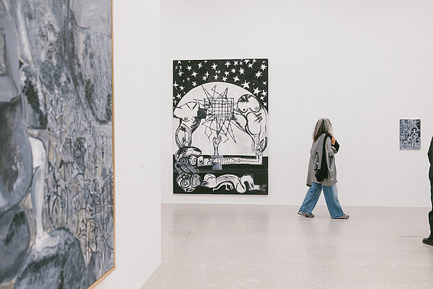 
            
                Visitors in the Tobias Pils. Shh exhibition at mumok, standing in front of color-reduced paintings.
            
        