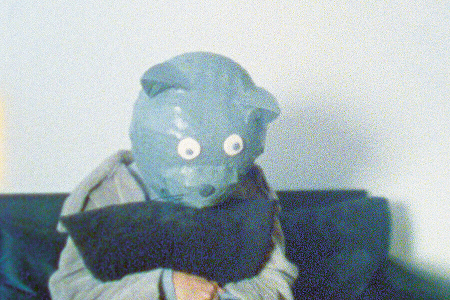 Film Still: Gernot Wieland, Thievery and Songs. Person mit blauer Bärenmaske auf dem Kopf / Person with blue bear mask.