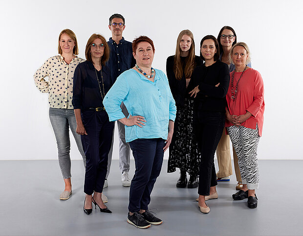
            
                eine Gruppe von Personen vor einer weißen Wand, das Team Ausstellungsmanagement im mumok
            
        