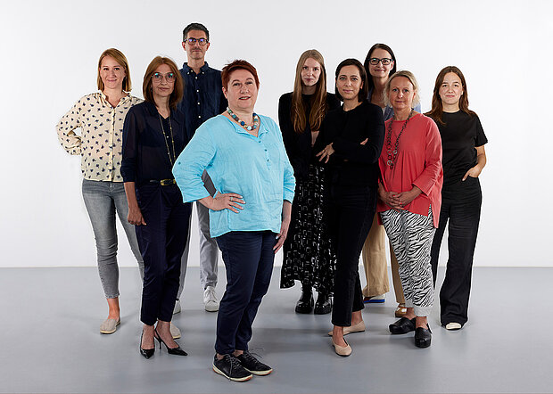 
            
                a group of people in front of a white wall, the exhibition management team at mumok
            
        