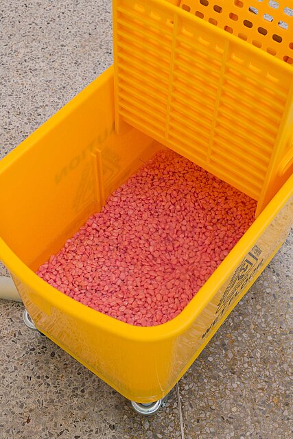  The detail shows a yellow cleaning bucket with pink plastic balls in it. 