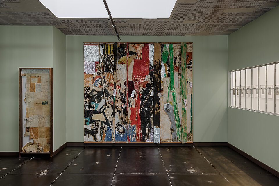 
            
                Hellgrüner Ausstellungsraum mit einer großformatigen collageartigen Bildarbeit
            
        